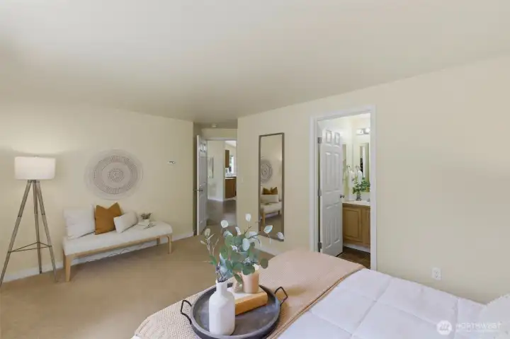 A spacious primary bedroom with room for a sitting area — calm, uncluttered, and full of light.