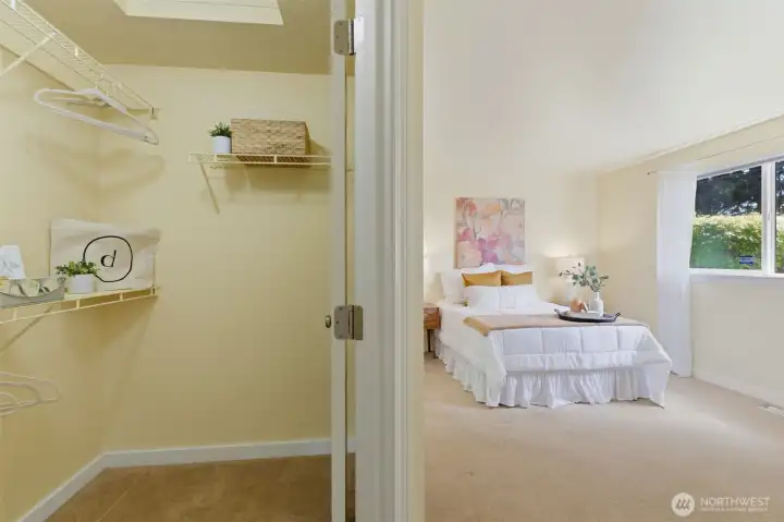 The primary suite features a spacious walk-in closet with built-in shelving — organized storage at its best.