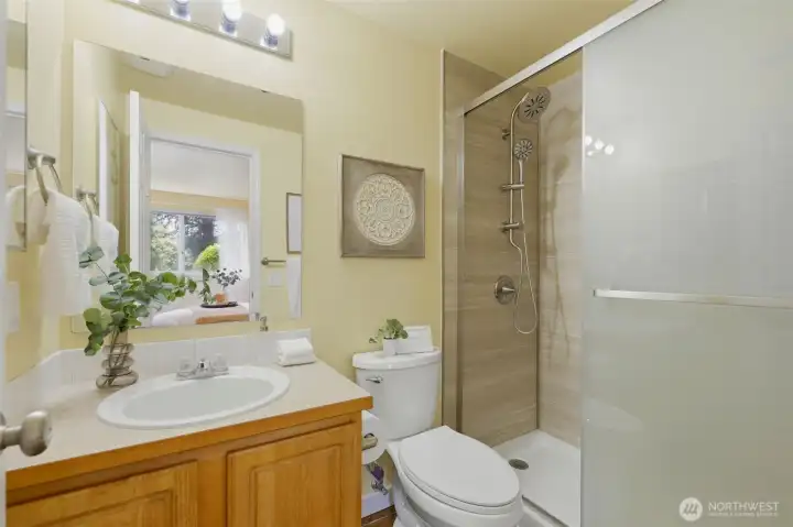 The en-suite bath showcases a newly installed Jacuzzi brand walk-in shower with dual shower heads — spa-style comfort at home.