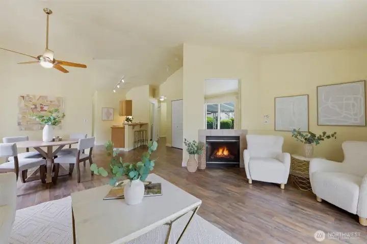 Open-concept main living with cozy gas fireplace, Luxury Vinyl Plank flooring, and seamless flow from dining to kitchen — comfortable single-level living.