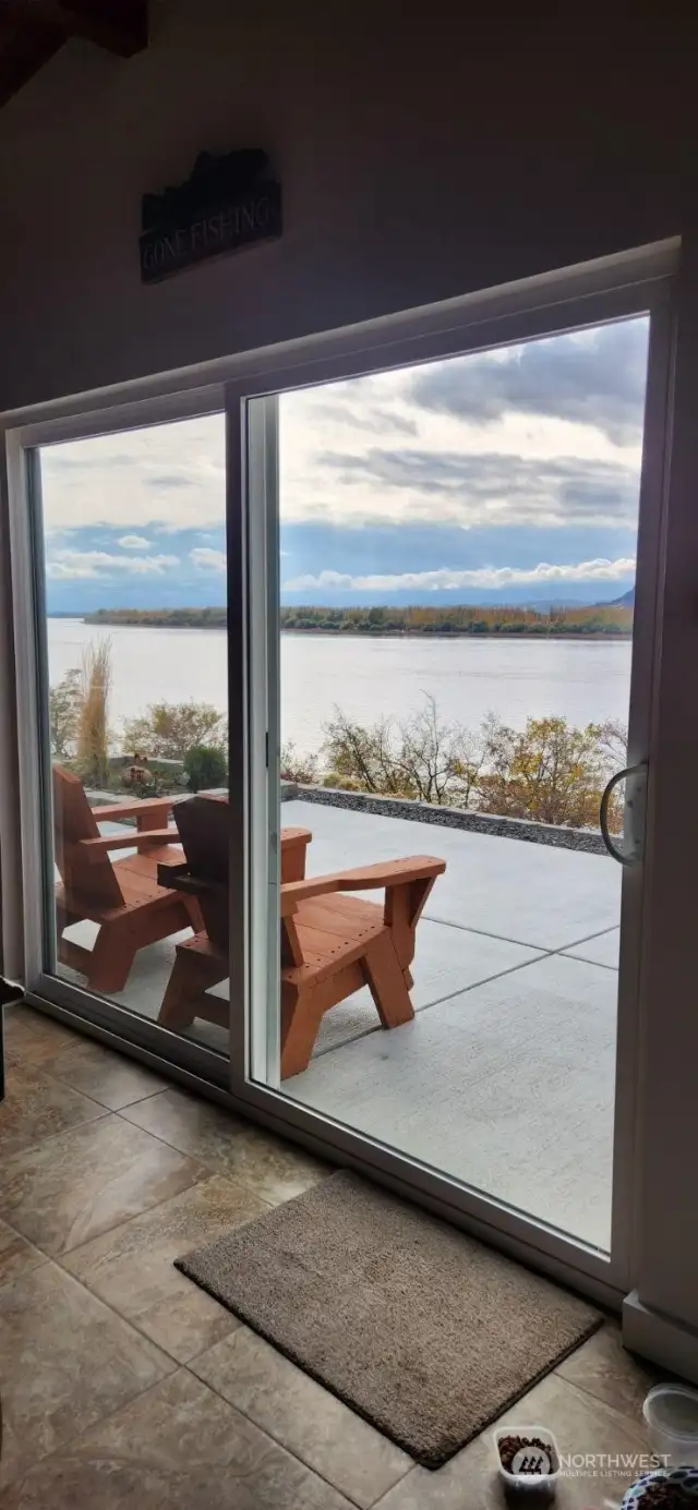 dining overlooking large concrete patio and 180'river views