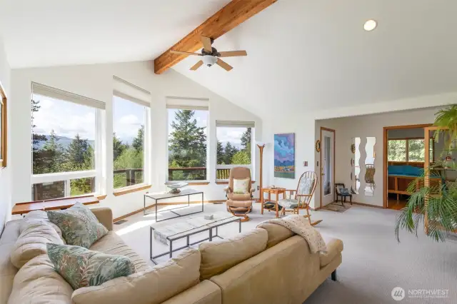 Open living space with vaulted ceilings and primary in the background