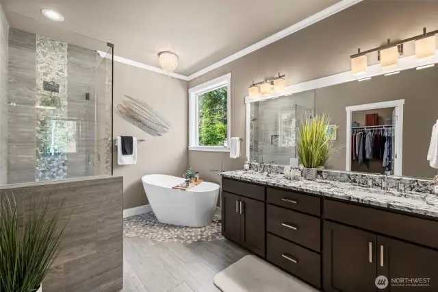 Welcome to this luxurious bathroom with a beautiful granite counter and two sinks, a soaking tub and a generous shower with custom tile.