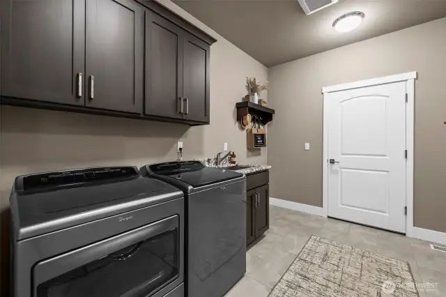 Plenty of room in this laundry area with a sink and cabinets.  It's right around the corner from the kitchen - simplify your life!