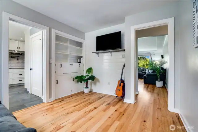 Just off the kitchen, this versatile bonus room offers built-in shelving and a dedicated space for a television—ideal for cozy movie nights or displaying decor. Add a desk, and it transforms into a perfect home office, blending functionality with comfort.