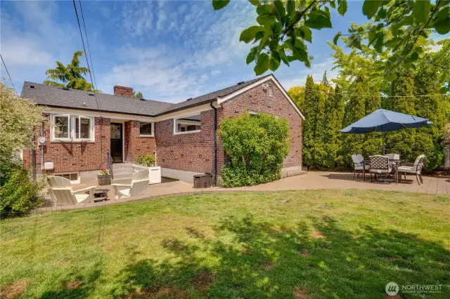 Featuring two beautifully crafted stone paver patios that border a large lawn area, this thoughtfully designed outdoor retreat offers endless possibilities for summer entertaining and fun.