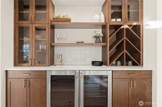 Beverage & Entertainment Bar features a Stainless Steel Double Beverage Cooler and wood and glass Cabinetry to store your glassware.
