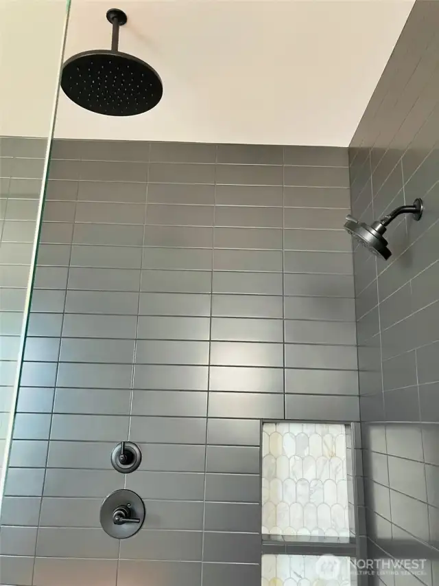 This Large Shower is appointed with a Rain Shower Head and a wall Shower head
