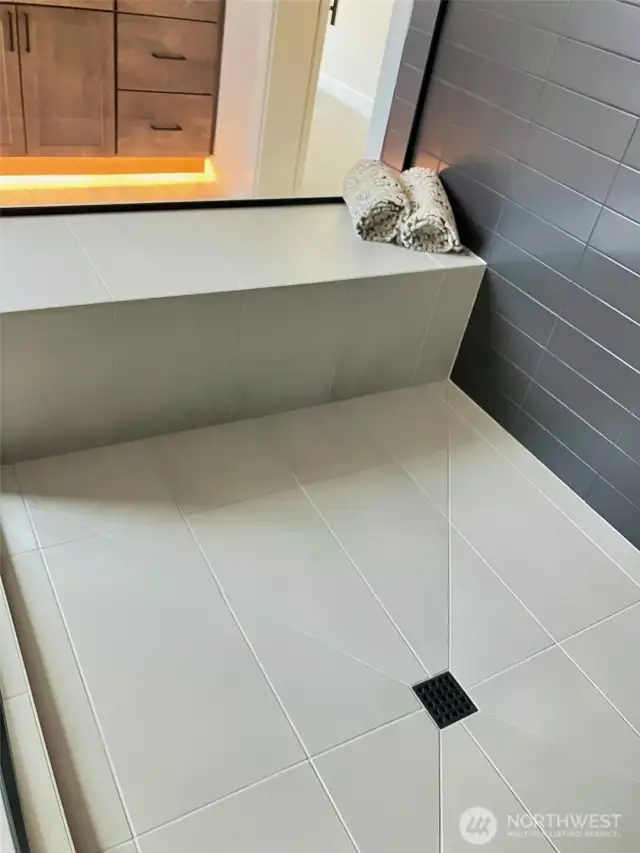 A Tiled Seat and Floor in the shower allows a place to sit & enjoy the large shower.