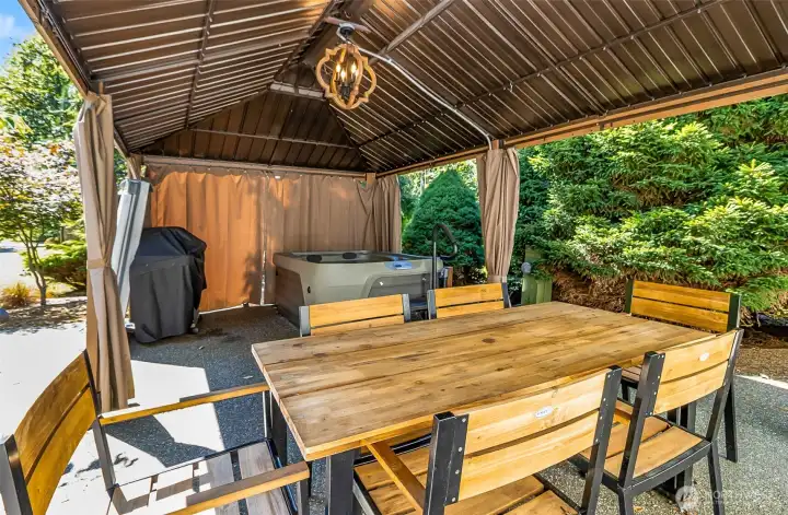 Ready for any weather, this covered patio includes dining space and a hot tub. Imagine relaxing or entertaining in this private sanctuary.