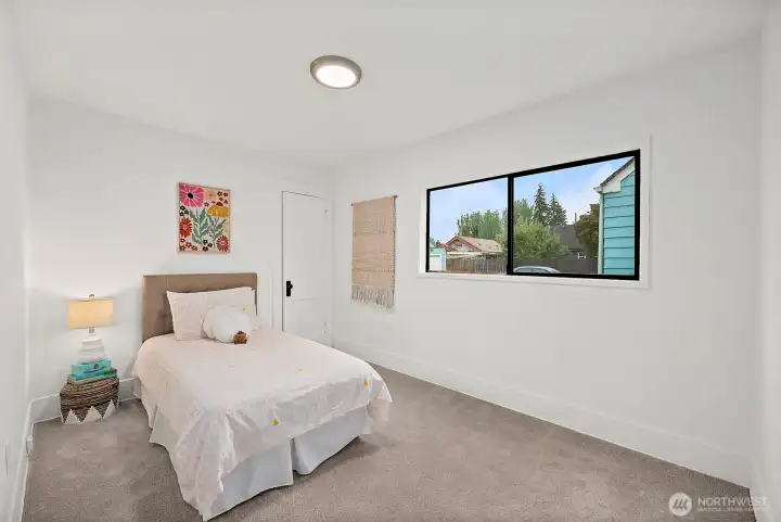 Room with soft carpet and large window.