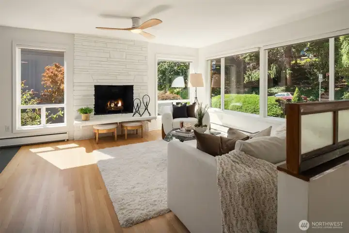 The living room is bathed in natural light from the large framed picture windows.