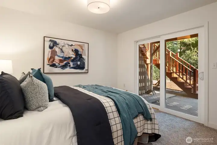 SW lower level bedroom with slider to patio and gardens.
