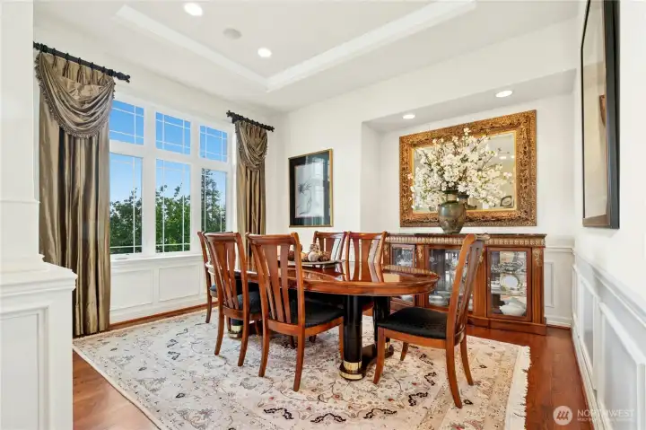 Elegant living room features a recessed ceiling and serene views of the landscaped grounds.