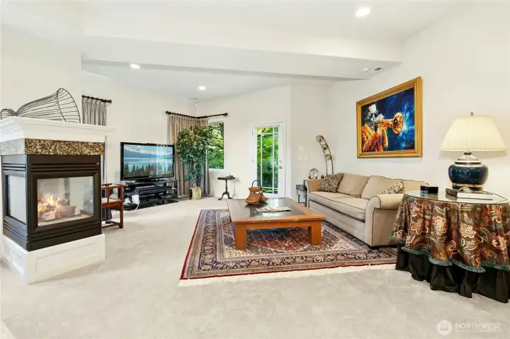 Warm and inviting, this lower-level living space features a cozy fireplace, ample room to relax, and direct access to the patio for seamless indoor-outdoor living.