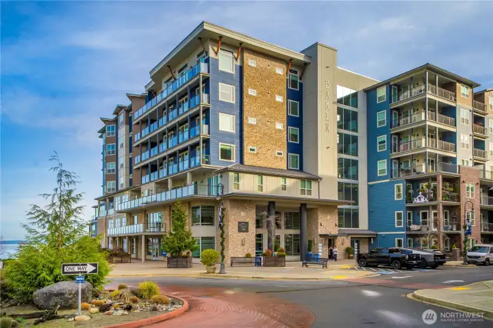 A striking exterior view of the Baker Building, ideally situated within the sought-after Point Ruston neighborhood. This prime location places you at the heart of a waterfront community known for its scenic paths, coastal breezes, open-air events, and an unmatched blend of entertainment and outdoor recreation.