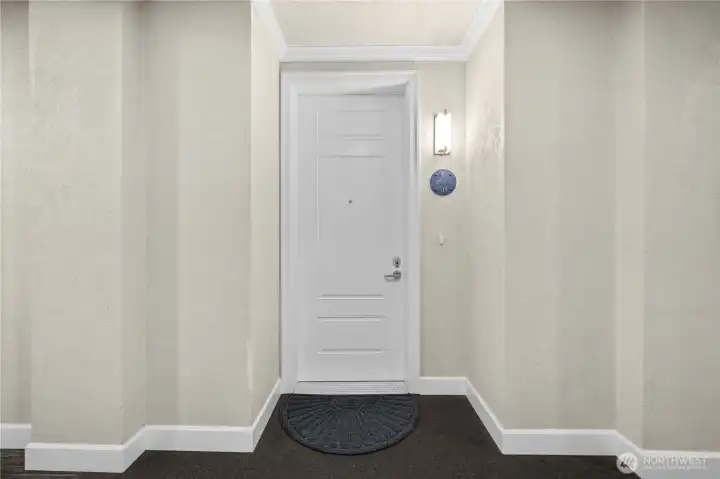 The secure interior hallway leads to the private entry of Unit 314, offering a quiet, well-maintained approach. This controlled-access environment adds comfort and peace of mind as you come and go.