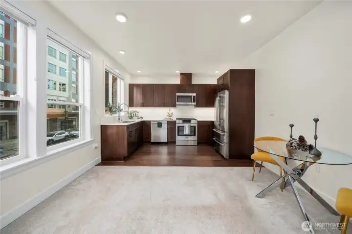 This bright, open kitchen flows seamlessly into the main living area, offering an inviting layout with large windows that bring in natural light. The thoughtfully designed space enhances everyday living and complements the vibrant Point Ruston setting just outside the windows.
