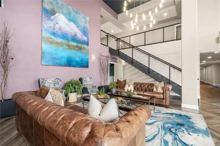 Another view of the lobby highlights its comfortable gathering spaces, modern décor, and impressive artwork. The open layout and sophisticated finishes create a warm and inviting first impression for residents and guests alike.