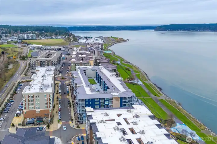 This elevated perspective captures the lively Point Ruston village area and the scenic waterfront trail that stretches for miles. Residents love the convenience of walking to shops, entertainment, and recreational paths with panoramic bay views.