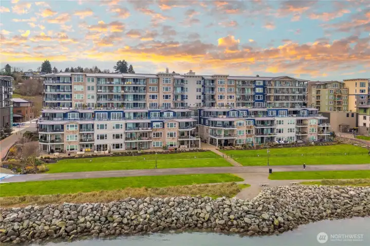 This waterfront view highlights how the Baker Building enjoys breathtaking evening skies over Commencement Bay. The surrounding parks and open spaces reflect the relaxed, outdoor-friendly lifestyle Point Ruston is known for.