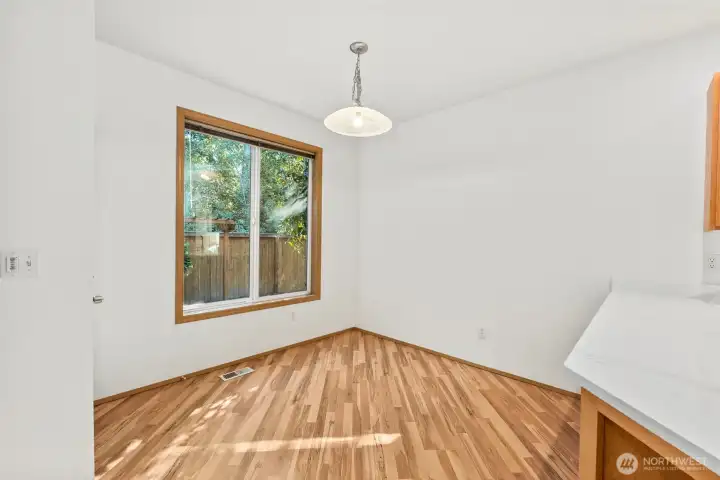 Dining room space off the kitchen, with access to backyard patio. Laminate hardwood flooring throughout main floor.