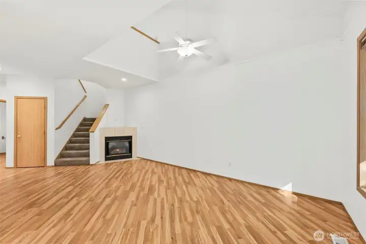 Large living room with laminate hardwood flooring, gas fireplace for cozy nights during the cooler fall and winter PNW months.