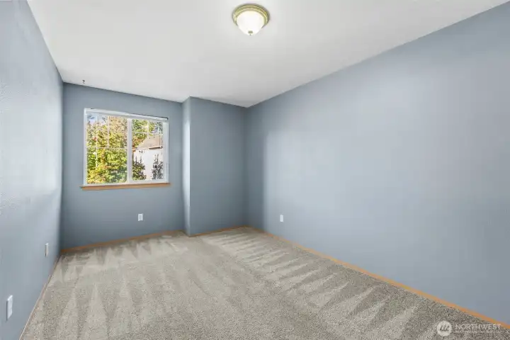 Bedroom 3 with wall-to-wall carpet, window looking out to the front yard/street.
