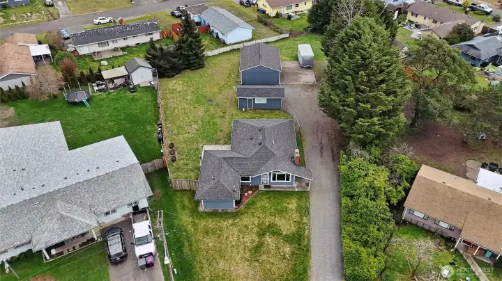 Aerial view showing large (just shy .45 acre) lot with 2 distinct detached buildings including 3-car garage/shop and addition flex space building.