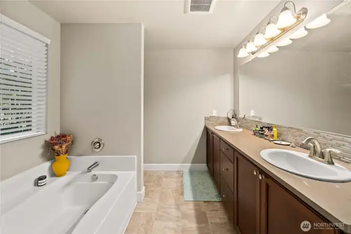 Primary en-suite full bathroom with dual sink vanity and large mirror