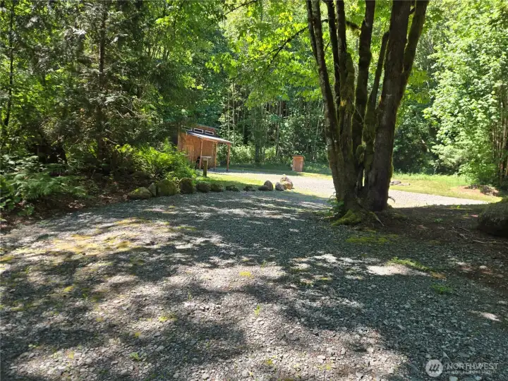 After a short hill, the driveway to lot 12's cleared and level home site has a circular driveway. This picture shows the left side of the circular drive and the large storage shed and future shop site.