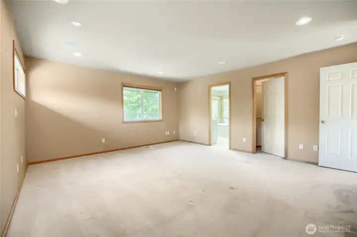 Another view of primary bedroom with walk in closet and separate linen closet.