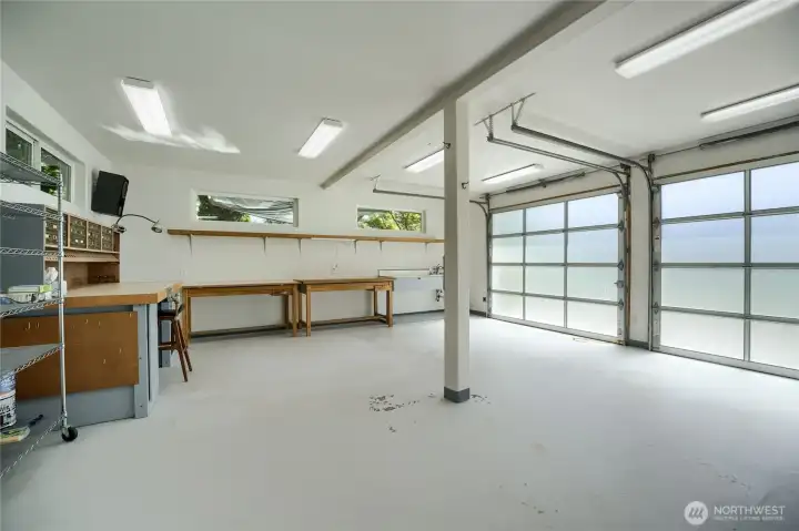 Main floor of detached shop with twin garage doors, full power and water.