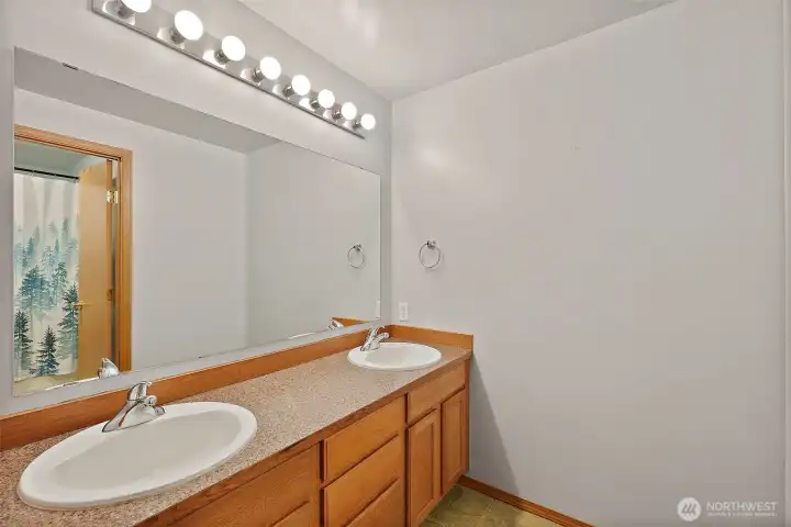 Double vanity with a door to the shower and toilet.