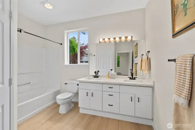 Updated Primary bath with dual under mounted sinks and quartz counter. Window allows for natural lighting