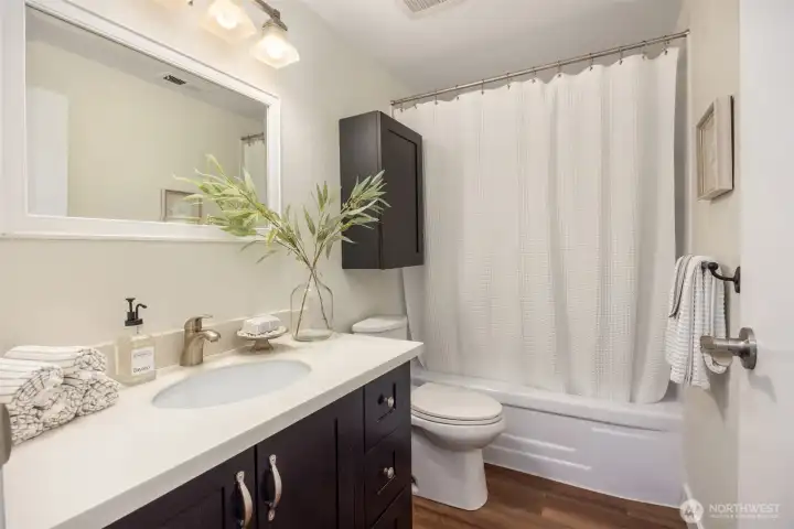 Beautifully updated bathroom featuring rich, dark wood cabinets.