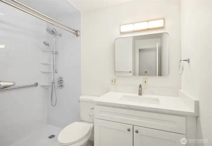 Hall bath with new cabinets, quartz counters, and toilet