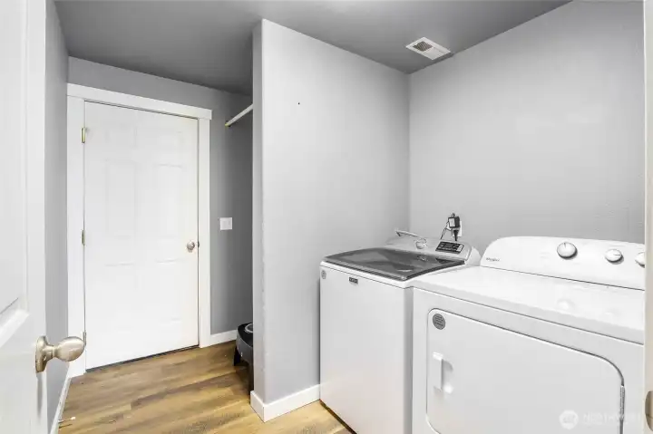 Roomy laundry room with additional storage under the stairs.