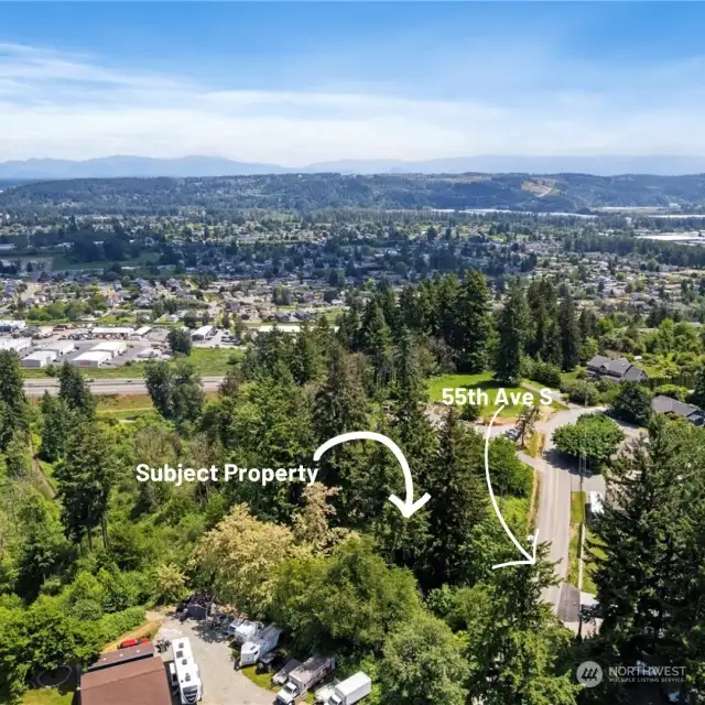 South direction aerial view.  Property is where the tall evergreens are.