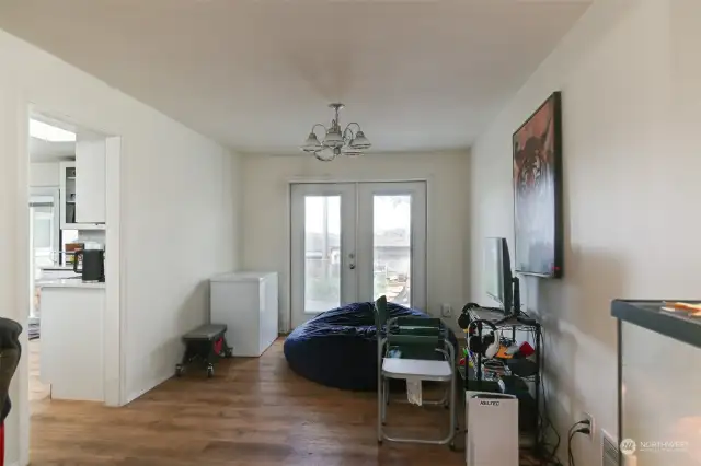 Formal dining adjacent to the kitchen that has a double door leading to the backyard .