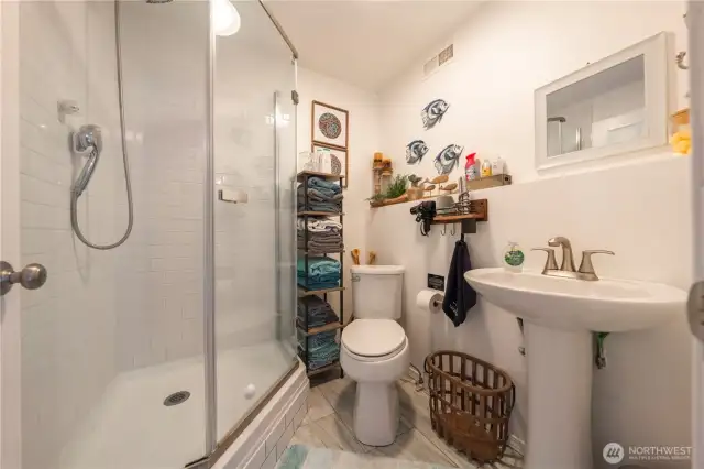 This studio bathroom features a newly remodeled design with a walk-in shower.