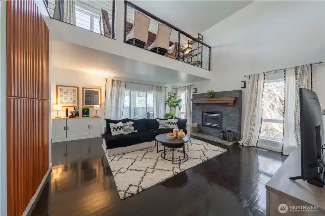 Vaulted ceilings, expansive views, and a striking stacked stone fireplace create a truly remarkable space.
