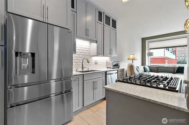 A five burner gas cooktop/oven with downdraft is perfect for home chefs who love precision cooking.  The four drawer refrigerator has a built-in ice maker and water dispenser.