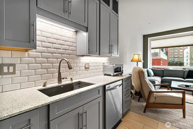 Classic subway backsplash compliments the quarts countertops and undermount sink makes cleanup effortless.