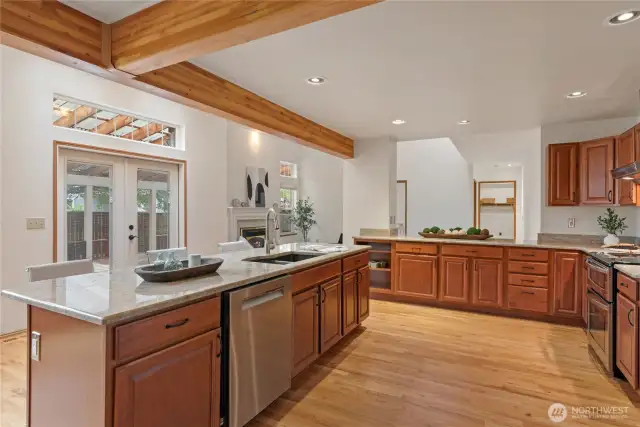 French doors from the kitchen open to an extensive covered deck, ideal for hosting events.