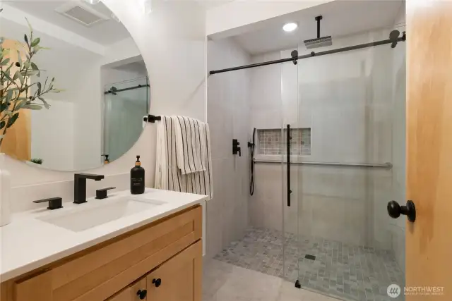 Remodeled three-quarter bathroom featuring heated flooring and a contemporary walk-in glass shower.