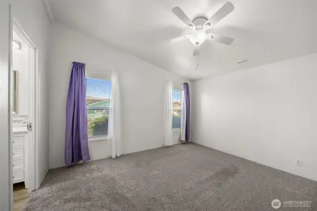Primary bedroom with newer carpet & ceiling fan.