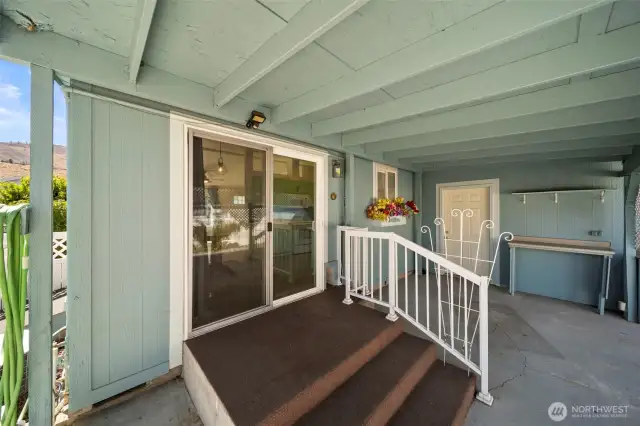 Sliders off the dining room to the covered patio area. Exterior man door to garage in background.