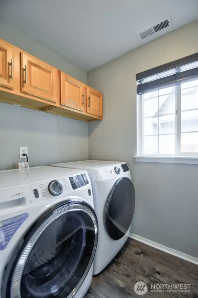 Laundry Room with newer washer and dryer and cabinets above.