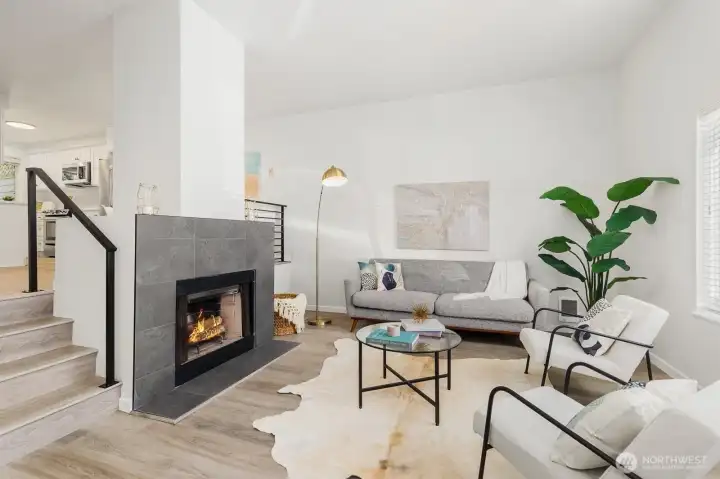 Bright and inviting living room featuring a cozy fireplace, modern finishes, and an open flow to the kitchen.
